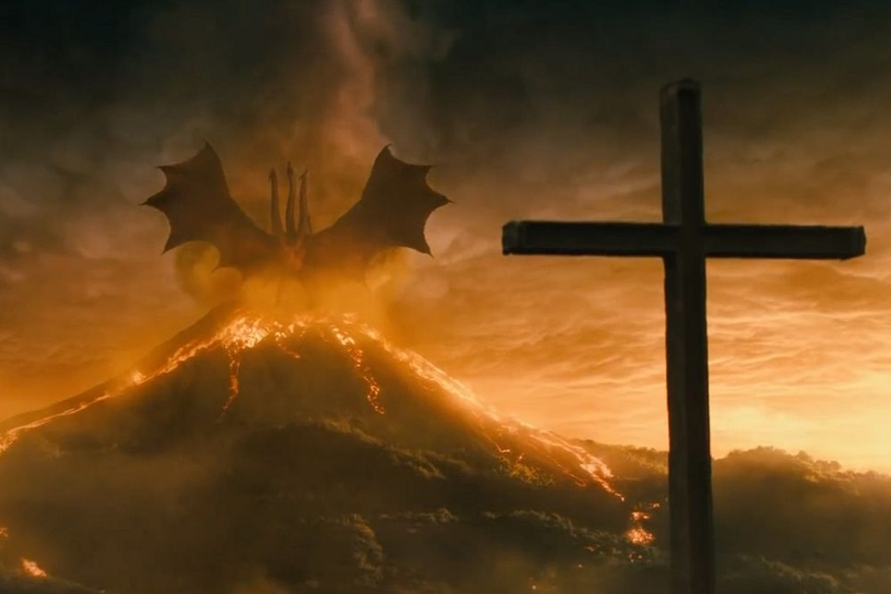 Phân cảnh quay cận một cây thánh giá sau King Ghidorah đang ngạo nghễ đứng trên miệng núi lửa