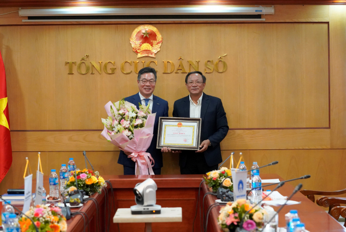 Tổng cục trưởng Nguyễn Doãn Tú trao tặng đại điện Công ty KIS giấy khen ghi nhận những đóng góp cho công tác Dân số - Kế hoạch hóa gia đình