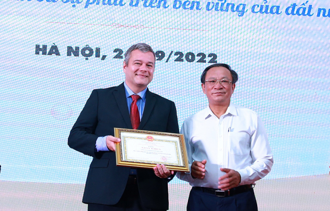 Ông Nguyễn Doãn Tú, Tổng cục trưởng Tổng cục Dân số - KHHGĐ trao tặng bằng khen cho ông Ingo Brandenburg, Tổng giám đốc Bayer Việt Nam