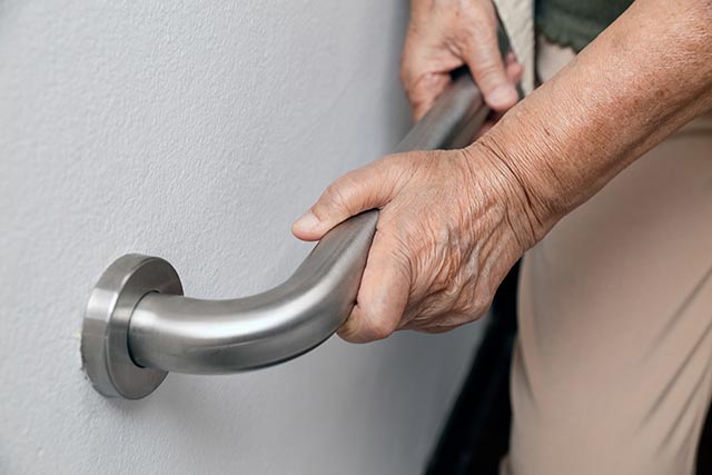 elderly-woman-holding-on-handrail-for-safety-walk-steps