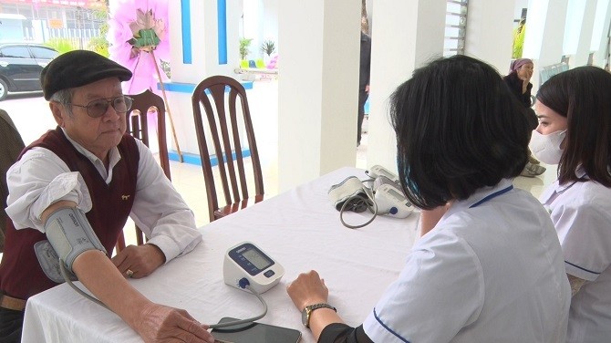 Nhân viên y tế kiểm tra sức khỏe cho người cao tuổi tại trạm y tế xã.