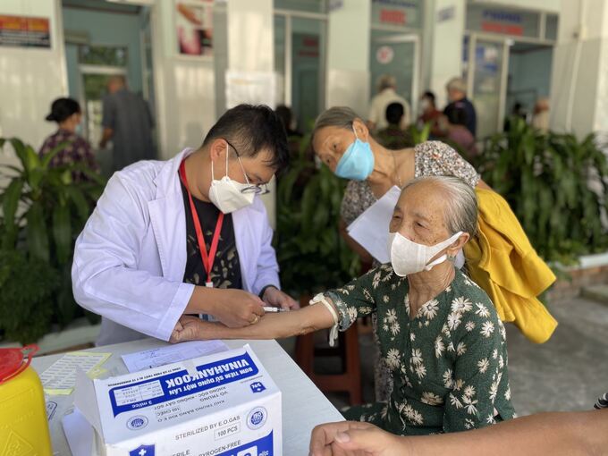 Bác sĩ lấy máu xét nghiệm cho người cao tuổi.