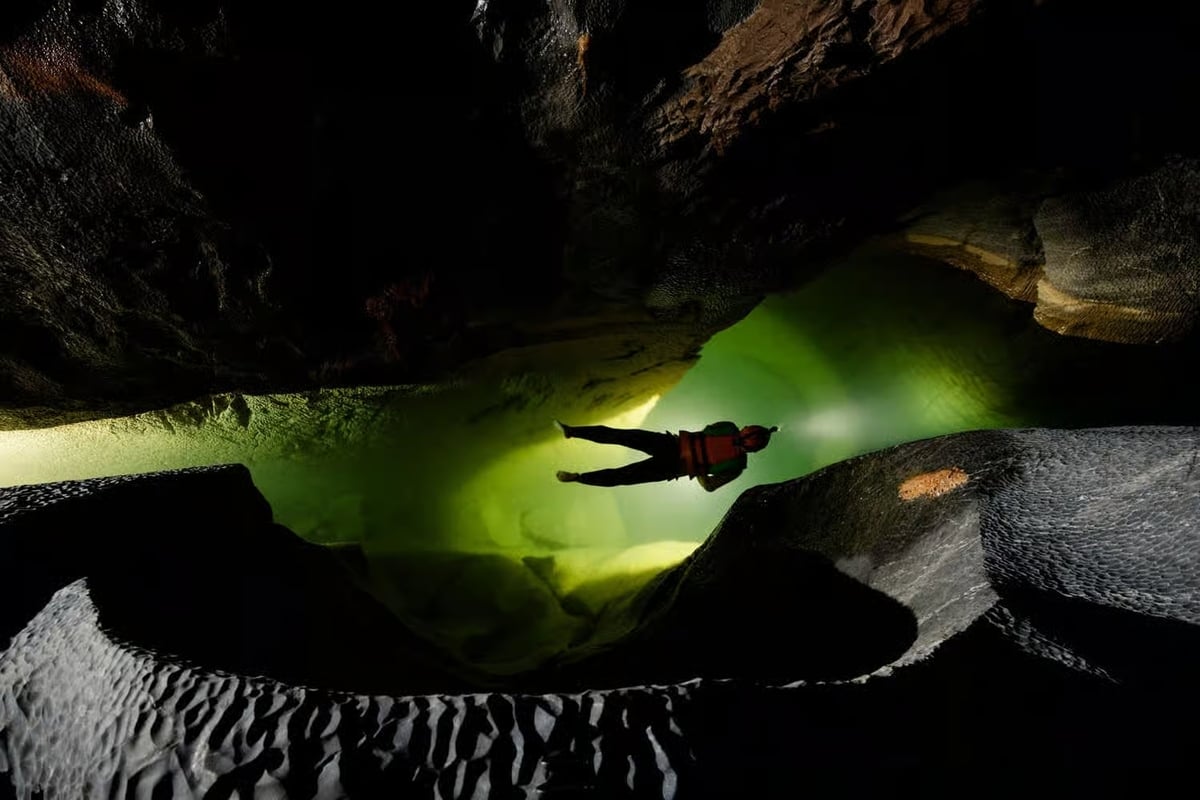 Bơi giữa một nhánh sông ngầm tại hành lang hóa thạch bên trong Hang Sơn Đoòng (Ảnh: Oxalis Adventure)