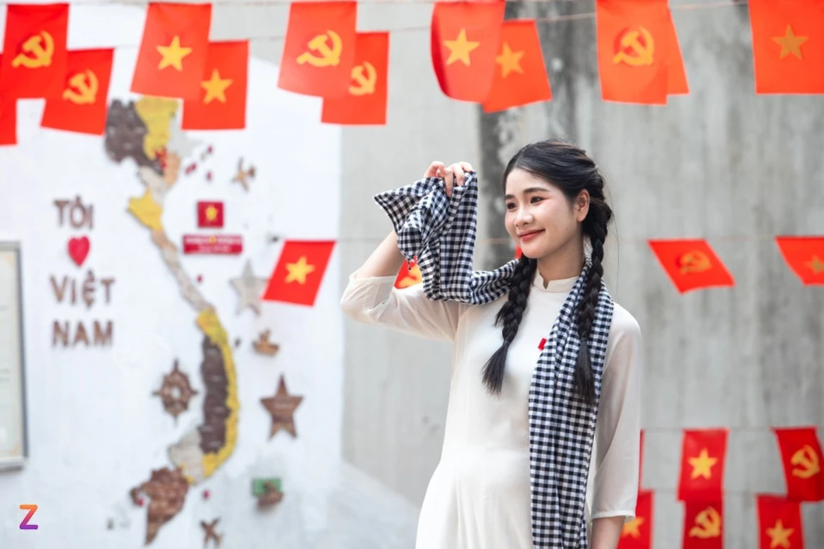 Nữ sinh chụp ảnh tại ngõ 'cờ đỏ sao vàng' ở Hà Nội (Ảnh: Việt Hà/Znews)