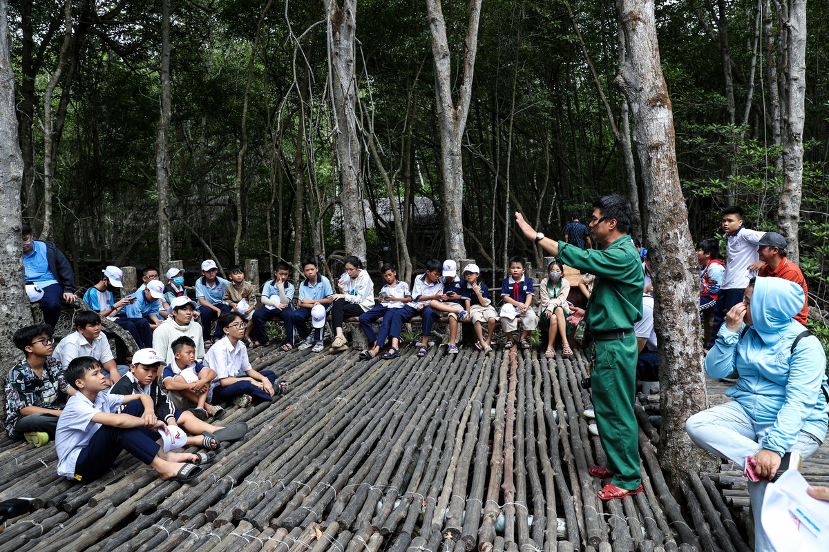Các em nghe kể về những chiến công, sự hy sinh anh dũng của cán bộ, chiến sĩ đặc công Rừng Sác (Ảnh: Báo Thanh Niên)