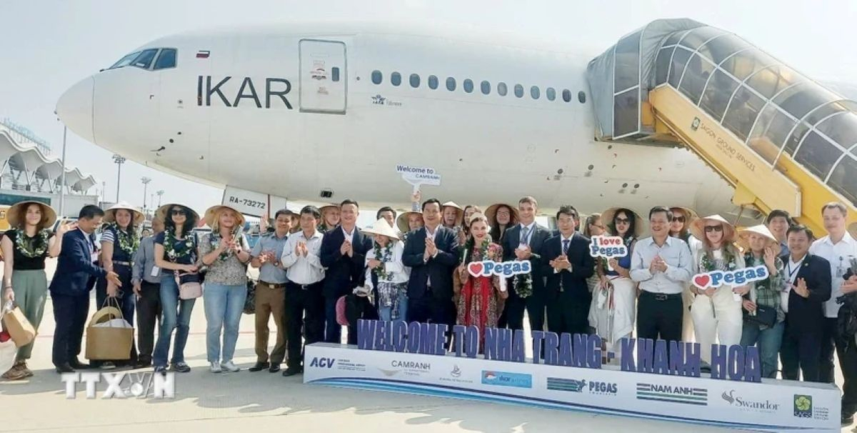 Du khách Nga chụp ảnh lưu niệm sau khi đặt chân đến sân bay quốc tế Cam Ranh (Ảnh: Tiên Minh/TTXVN)