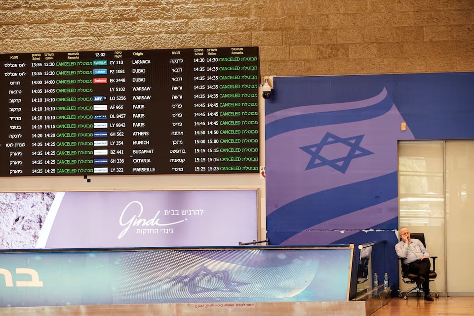 Một nhân viên của Sân bay quốc tế Ben Gurion ngồi tại nhà ga đến khi tất cả các chuyến bay đến và đi từ sân bay được thông báo hủy, sau cuộc tấn công của Israel vào Iran tại Lod gần Tel Aviv, Israel ngày 13/6/2025. (Ảnh: Reuters)