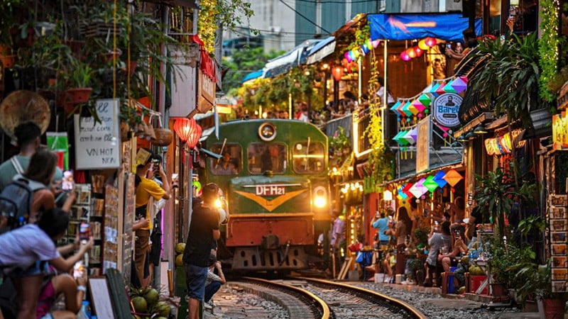 Du khách thư giãn và ngồi trải nghiệm đợi tàu đi qua (Ảnh: Internet)