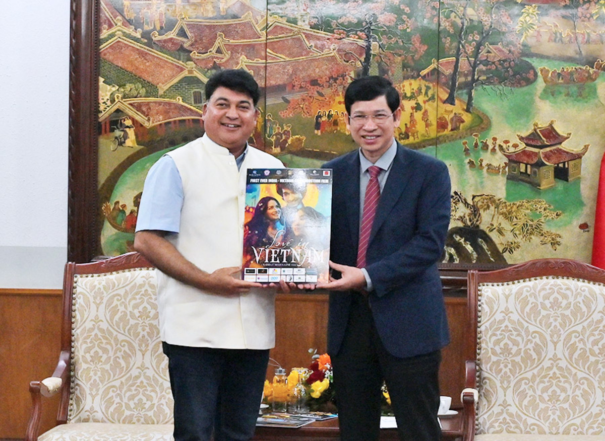 Thứ trưởng Bộ VHTTDL Hồ An Phong chụp hình lưu niệm bên poster phim Love in Vietnam (Ảnh: TITC)