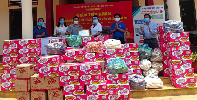 Chị Nguyễn Thị Ngọc Minh, Chi hội trưởng Chi hội Nữ doanh nhân TP Đồng Xoài (thứ 3, phải sang) cùng Bí thư Tỉnh Đoàn Trần Quốc Duy (thứ 2, phải sang) trao nhu yếu phẩm, rau củ quả và vật tư y tế cho huyện Lộc Ninh
