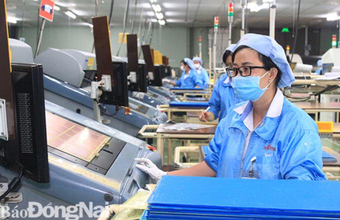 Người lao động Công ty TNHH Sản phẩm máy tính Fujitsu Việt Nam (KCN Biên Hòa 2, TP.Biên Hòa) sản xuất 3 tại chỗ (ảnh: Hạnh Dung)
