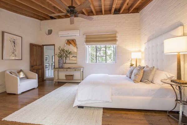 Một trong năm phòng ngủ của khách duy trì bầu không khí nhẹ nhàng với những bức tường gạch trắng