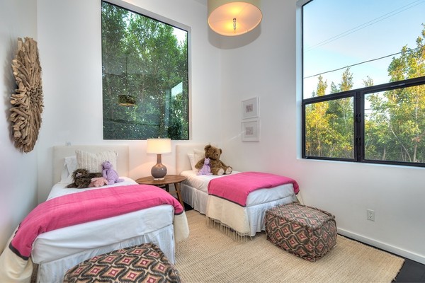 Chăn màu hồng ấm cúng thêm một màu sắc cho hai giường đôi trong phòng trẻ em.