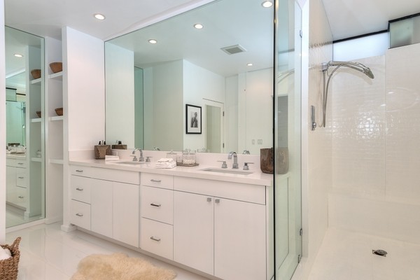 Tủ màu trắng, sàn và gạch bao phủ phòng tắm chính, tạo ra một bầu không khí sạch sẽ.