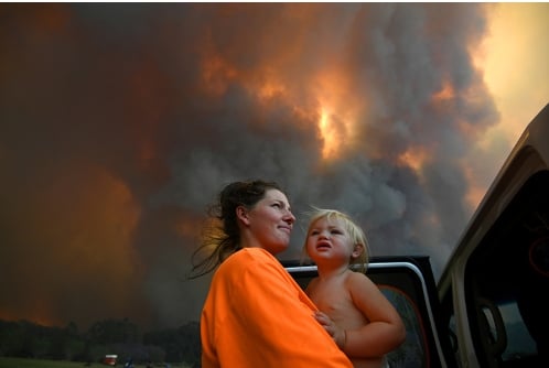 Sharnie Moren và con gái Charlotte, 18 tháng tuổi, đứng giữa làn khói bốc lên ngùn ngụt gần làng Nana Glen, bang New South Wales, Australia