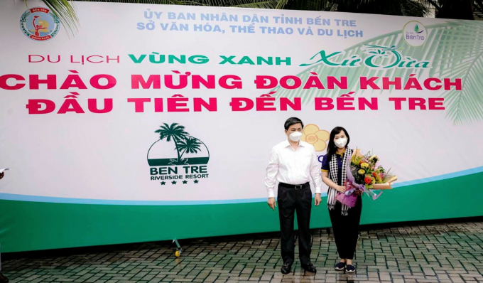 Ông Lê Đức Thọ, Ủy viên BCH Trung ương Đảng, Bí thư Tỉnh ủy Bến Tre trao hoa chúc mừng du khách TP Hồ Chí Minh đầu tiên đến Bến Tre sau thời gian giãn cách.