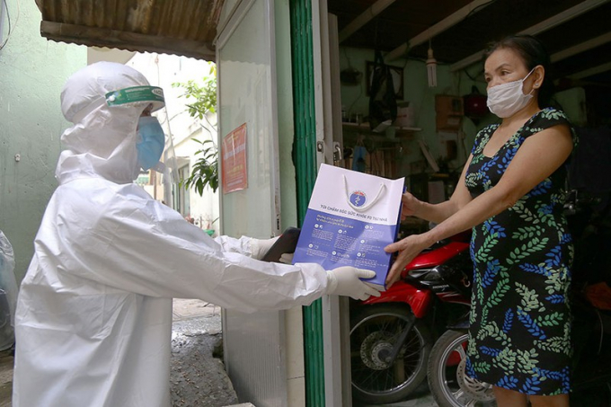 Nhân viên y tế phát thuốc cho F0 điều trị tại nhà ở phường 12, quận Bình Thạnh, TP.HCM. Ảnh: HOÀNG GIANG