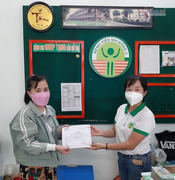 Cán bộ phòng Công tác xã hội (bên phải) trao thư cảm ơn cho chị Phấn.