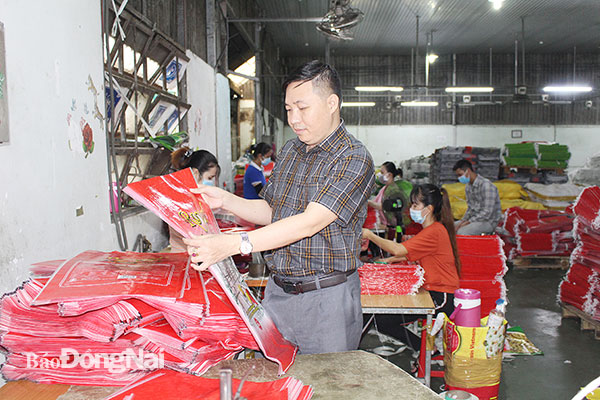 Ông Phạm Văn Chính kiểm tra một sản phẩm bao bì hoàn thiện. Ảnh: Văn Gia
