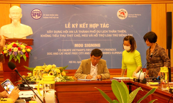 Ông Nguyễn Thế Hùng, Phó chủ tịch UBND TP Hội An, ký thỏa thuận với tổ chức FOUR PAWS về cam kết loại bỏ việc sử dụng thịt chó và mèo. Ảnh: Thanh Đức.
