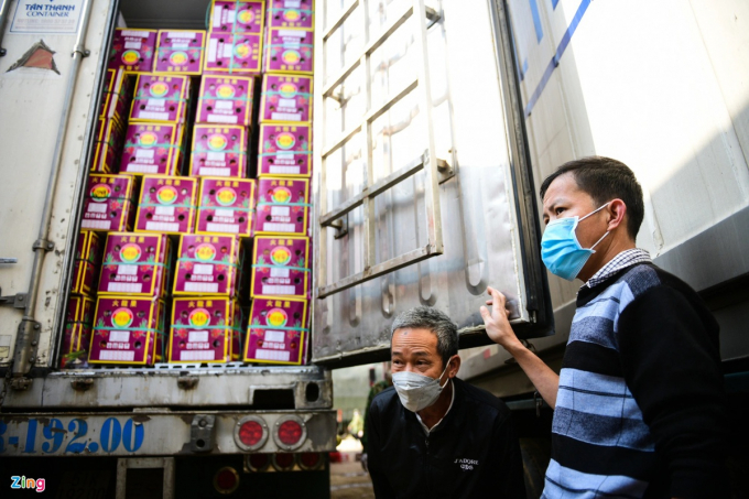 Ngày nào ông Huỳnh Văn Chức (phải) cũng mở thùng lạnh để kiểm tra gần 25 tấn thanh long của mình vì lo sợ sẽ hư hỏng khi mắc kẹt ở cửa khẩu Tân Thanh. Ảnh: Thạch Thảo.