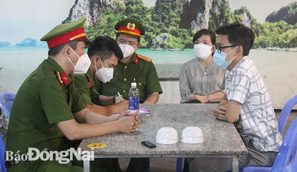Đoàn kiểm tra làm việc với chủ một cơ sở kinh doanh vi phạm phòng dịch tại P.Thống Nhất, TP.Biên Hòa. Ảnh: Trần Danh