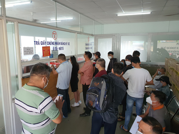 Người dân đi nhận trả kết quả ở điểm đăng ký xe tại TP.HCM - Ảnh: MINH HÒA