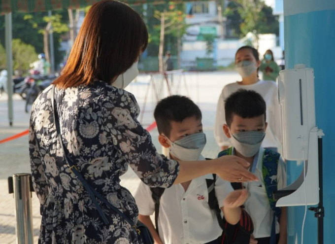 Trường Tiểu học Bông Sao (quận 8) phân luồng, bố trí đo nhiệt độ, rửa tay cho học sinh trước khi vào lớp. Ảnh: NH.