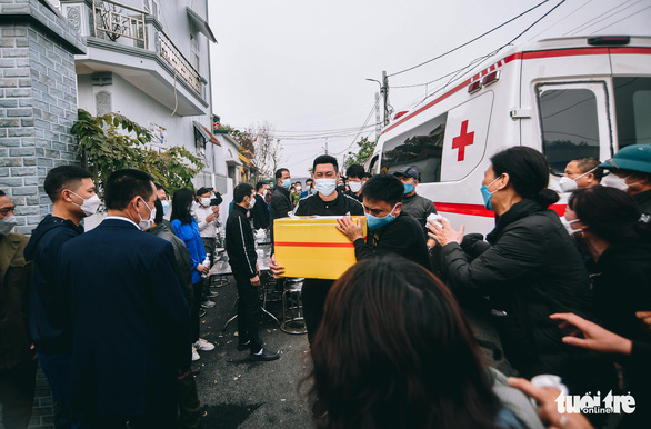 10h sáng 28-2, tro cốt của các nạn nhân được chuyển từ xe cứu thương vào nhà để bàn giao cho gia đình