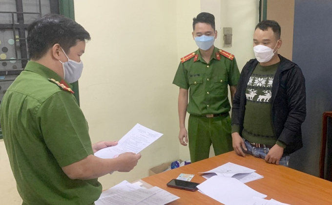 Cơ quan chức năng tống đạt quyết định khởi tố, tạm giam Nguyễn Văn Hà (bên phải) NGUYỄN TÚ