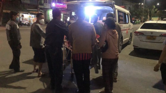 Người nhà dùng băng ca đẩy bệnh nhân ra xe cấp cứu đậu ngoài khuôn viên bệnh viện