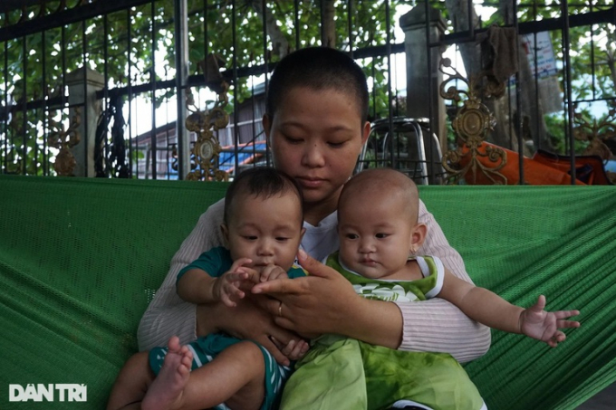 Một nách ôm 3 đứa con, chị Hồng không thể dứt ra để làm việc gì, cuộc sống rơi vào bí bách (Ảnh: Nguyễn Cường).