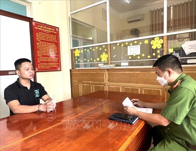 Công an lấy lời khai đối tượng Trần Quang Quyền, một trong 8 người bị bắt giữ. Ảnh: TTXVN phát