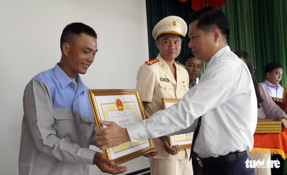 Anh Nguyễn Văn Quốc nhận bằng khen vì hành động dũng cảm cứu người - Ảnh: ĐÔNG HÀ