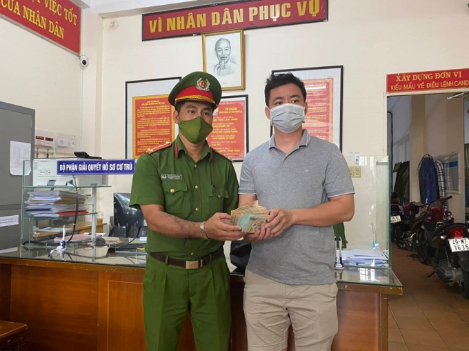 Đại úy Nguyễn Đức Dũng trao trả 300 triệu đồng cho anh Đỗ Quốc Anh tại trụ sở Công an phường 1, TP Đà Lạt.