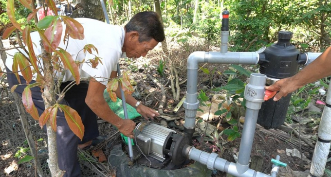 Ông Huỳnh Vinh Võ sử dụng hệ thống tưới tiết kiệm để bón phân cho cây giúp giảm lượng phân sử dụng. Ảnh: PV