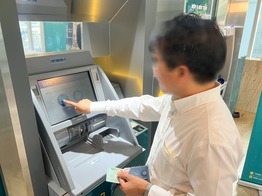 Người dân thực hiện xác thực dấu vân tay khi rút tiền bằng thẻ CCCD gắn chip tại cây ATM trên địa bàn quận Hoàn Kiếm (Hà Nội) - Ảnh: Nguyễn Hưởng