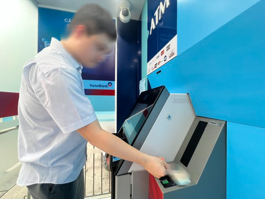 Người dân rút tiền bằng thẻ CCCD gắn chip tại cây ATM trên địa bàn quận Hoàn Kiếm (Hà Nội) - Ảnh: Nguyễn Hưởng