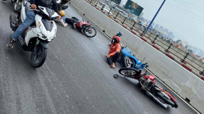 Nhiều người đi xe máy bị trượt ngã do dầu nhớt đổ trên cầu Sài Gòn.