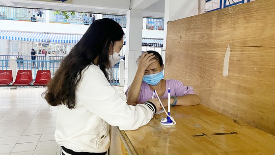 Người phụ nữ dẫn phóng viên vào khám nhanh tại Trung tâm Y khoa Medic Hòa Hảo, quận 10. Ảnh: BÙI TUẤN