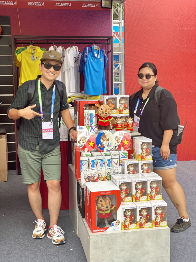 Anh Nguyễn Thuận Thành (trái) bên các con thú bông sao la và quà lưu niệm SEA Games 31 được bán trước các sân vận động NVCC