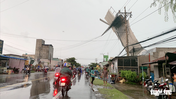 Mái tôn của một nhà dân ở huyện Chợ Gạo, tỉnh Tiền Giang bị lốc xoáy nằm dính trên trụ điện - Ảnh: HOÀI THƯƠNG