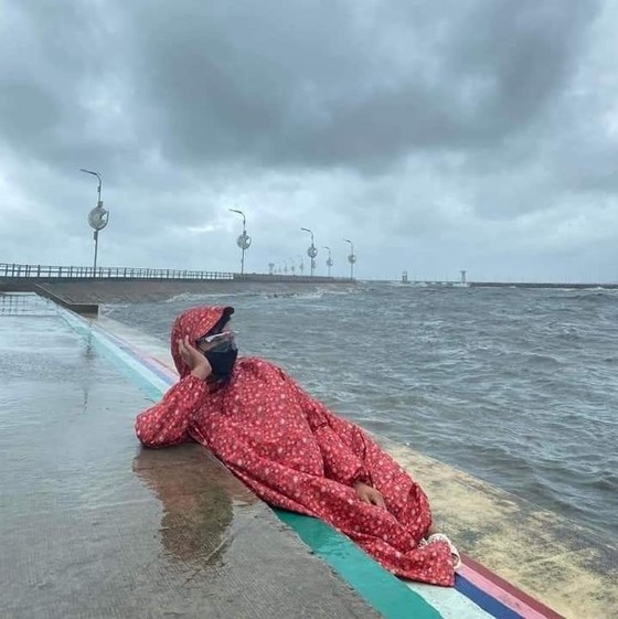Một du khách mặc nguyên áo mưa, chụp một bức ảnh với biển Phú Quốc để khỏi phí công đến Phú Quốc. Ảnh: Mạng xã hội