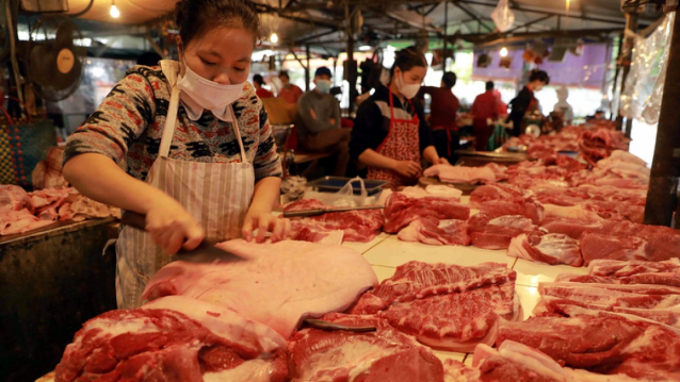 Nhiều chợ và siêu thị thường xuyên điều chỉnh giá bán thịt lợn. (Ảnh: TTXVN)