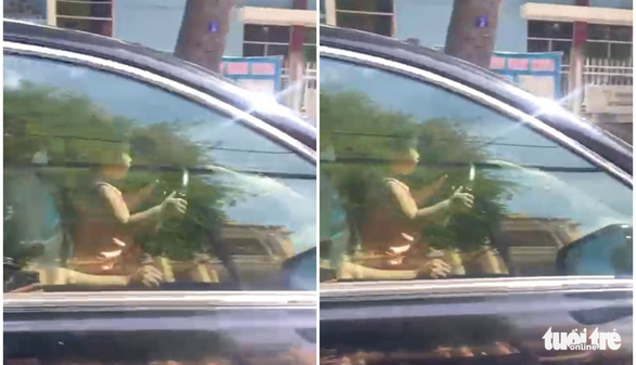 Hình ảnh người đàn ông để bé gái ngồi phía trước trên ghế lái, bé gái ôm vôlăng lái xe chạy trên đường - Ảnh: Cắt từ clip