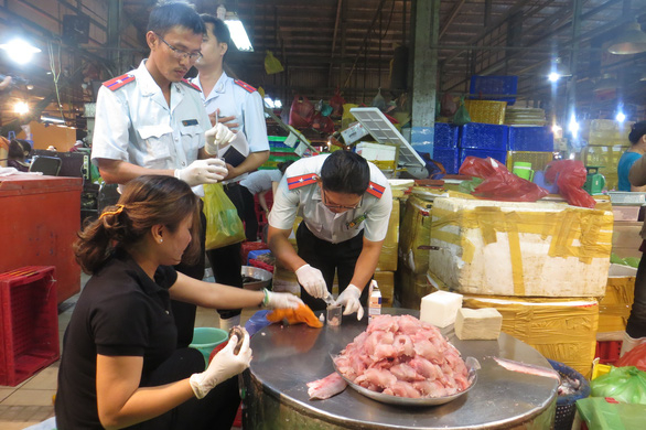Lực lượng Ban an toàn thực phẩm lấy mẫu thủy hải sản tại chợ Bình Điền (TP.HCM) để kiểm tra - Ảnh: N.TRÍ