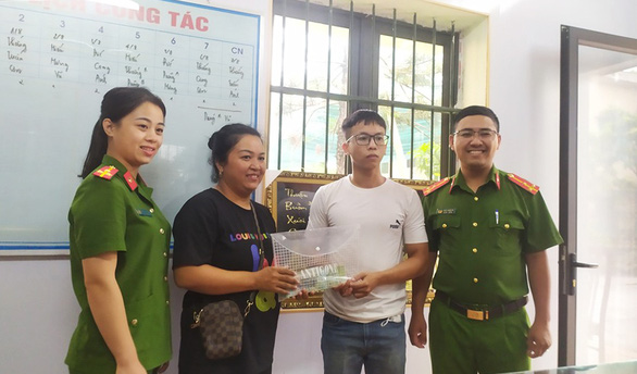 Anh Cao Tiến Ninh (áo trắng) trao lại số tiền mặt 102 triệu đồng nhặt được vào sáng 2-8, cho người đánh rơi là chị Nguyễn Thị Thanh Dung - Ảnh: KHÁNH LINH