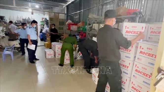 Lực lượng chức năng kiểm đếm số tang vật tạm giữ tại cơ sở kinh doanh của Nguyễn Văn Lý. Ảnh: TTXVN phát