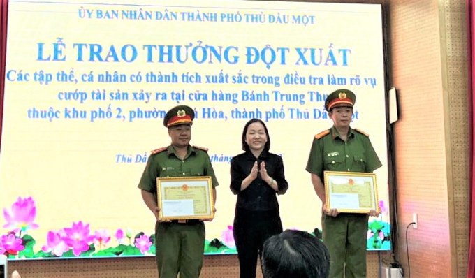 Bà Nguyễn Thu Cúc (giữa), tặng giấy khen 2 tập thể tham gia phá nhanh vụ án cướp bánh trung thu.