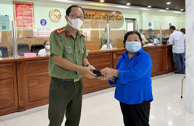 Đại úy Trần Vi Khánh trao trả chiếc bóp kèm tài sản có giá trị cho bà Dung.